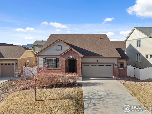 view of front of property with brick siding, concrete driveway, an attached garage, a gate, and fence