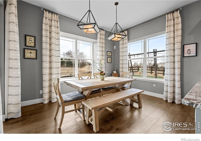 dining space with baseboards and dark wood-style flooring