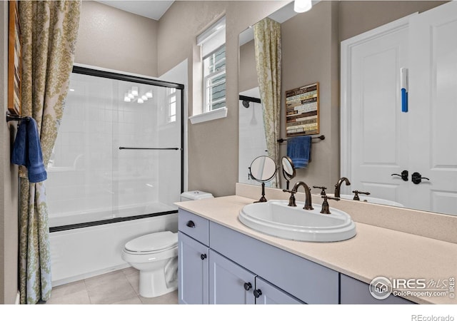 full bathroom featuring enclosed tub / shower combo, vanity, toilet, and tile patterned floors