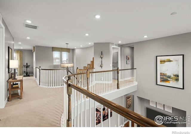 corridor with recessed lighting, visible vents, light colored carpet, and an upstairs landing