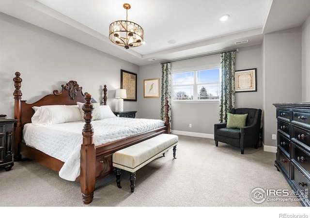 bedroom with a raised ceiling, light colored carpet, visible vents, a chandelier, and baseboards