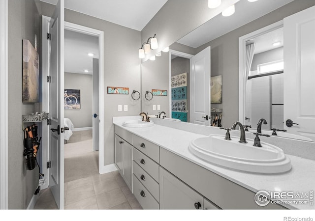 full bath with double vanity, ensuite bathroom, a sink, and tile patterned floors