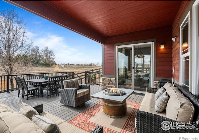 deck featuring outdoor dining area and an outdoor living space with a fire pit