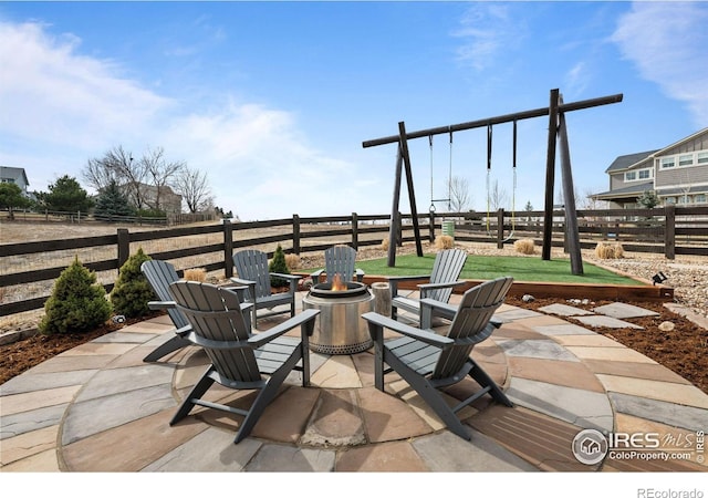 view of patio featuring an outdoor fire pit and fence