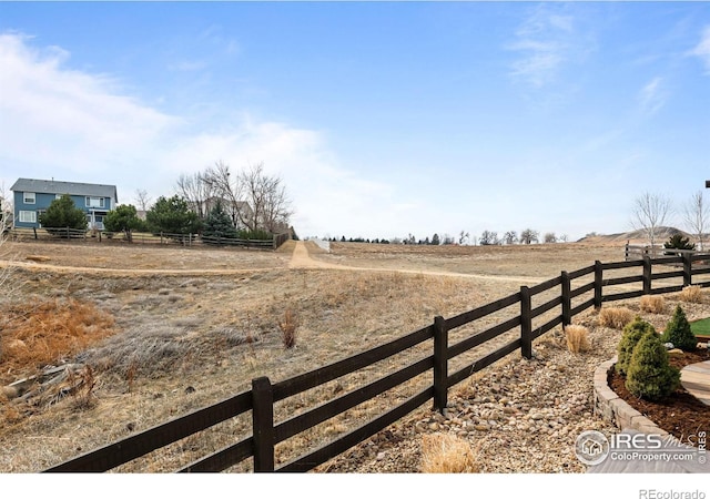 view of yard with a rural view and fence