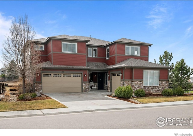 prairie-style home with concrete driveway, a garage, stone siding, and a shingled roof