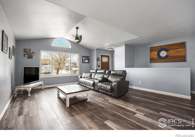 living room featuring lofted ceiling, a textured ceiling, baseboards, and wood finished floors