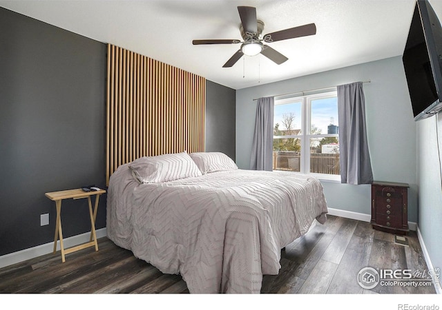 bedroom featuring dark wood-style floors, a ceiling fan, and baseboards