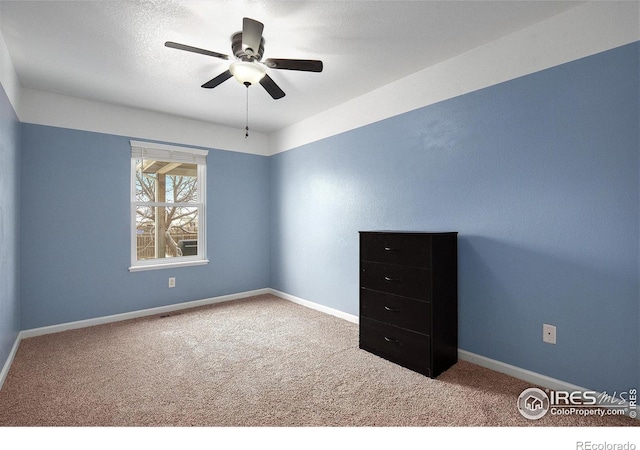 unfurnished bedroom with carpet flooring, a ceiling fan, and baseboards