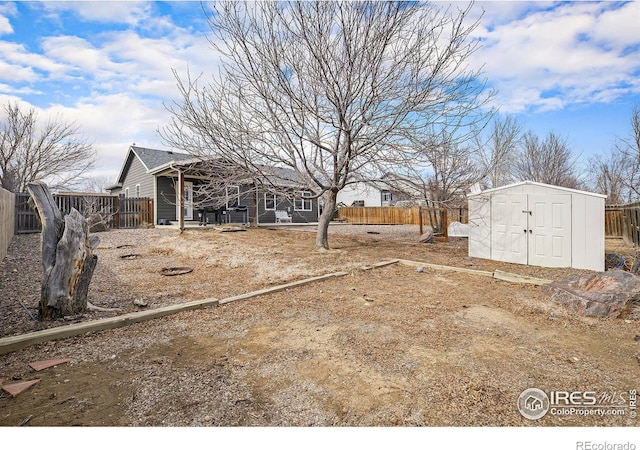 view of yard with an outbuilding, a storage unit, and a fenced backyard