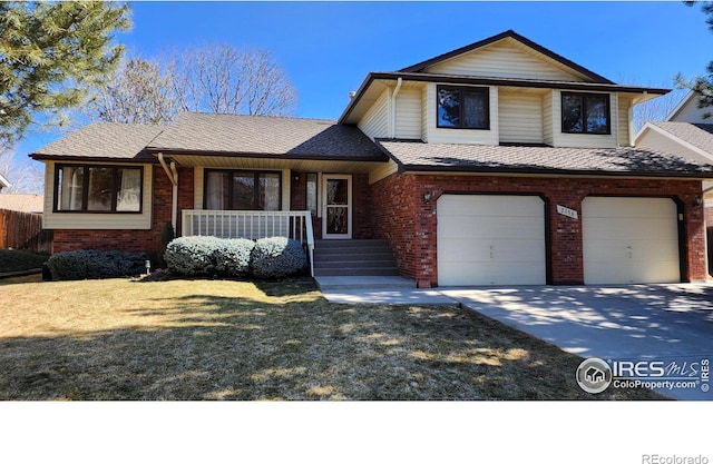 tri-level home with covered porch, driveway, brick siding, and an attached garage