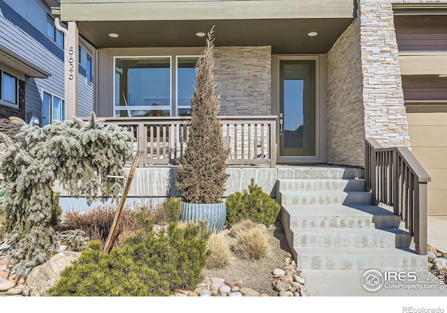 doorway to property featuring stone siding and covered porch