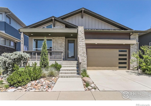5626 Four Leaf Dr, Longmont, CO 80503 - view of front of house featuring stone siding, board and batten siding, covered porch, driveway, and a garage