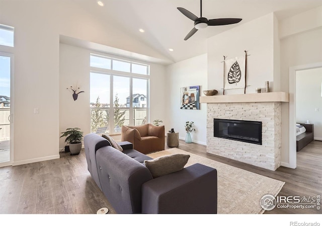 5626 Four Leaf Dr, Longmont, CO 80503 - living area featuring a fireplace, plenty of natural light, high vaulted ceiling, a ceiling fan, and wood finished floors