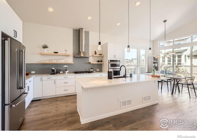 5626 Four Leaf Dr, Longmont, CO 80503 - kitchen featuring appliances with stainless steel finishes, wall chimney range hood, open shelves, tasteful backsplash, and white cabinetry
