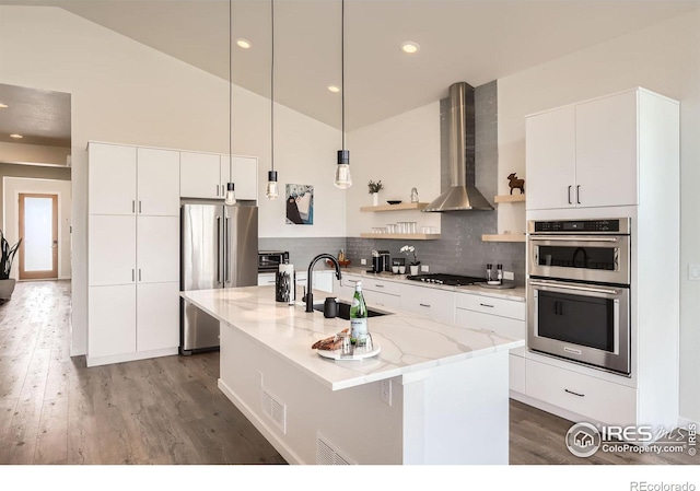5626 Four Leaf Dr, Longmont, CO 80503 - kitchen featuring wall chimney exhaust hood, stainless steel appliances, a sink, open shelves, and wood finished floors