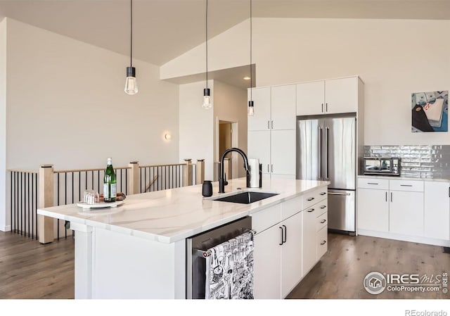 5626 Four Leaf Dr, Longmont, CO 80503 - kitchen featuring stainless steel appliances, a sink, wood finished floors, a center island with sink, and white cabinetry