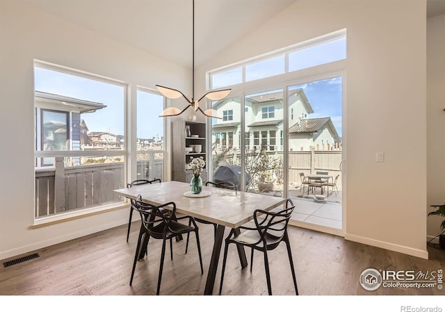 5626 Four Leaf Dr, Longmont, CO 80503 - dining space featuring baseboards, wood finished floors, and vaulted ceiling