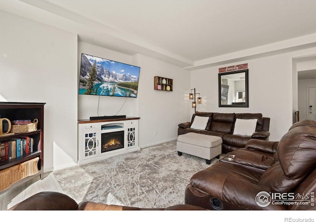 living area with carpet floors and a lit fireplace