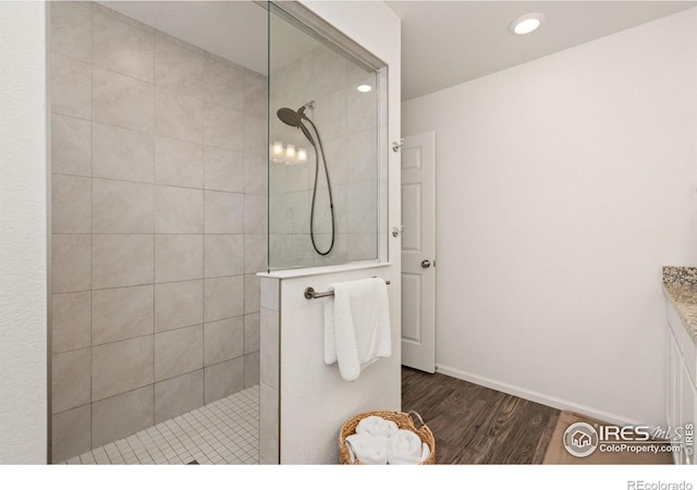 bathroom with wood finished floors, recessed lighting, walk in shower, and baseboards