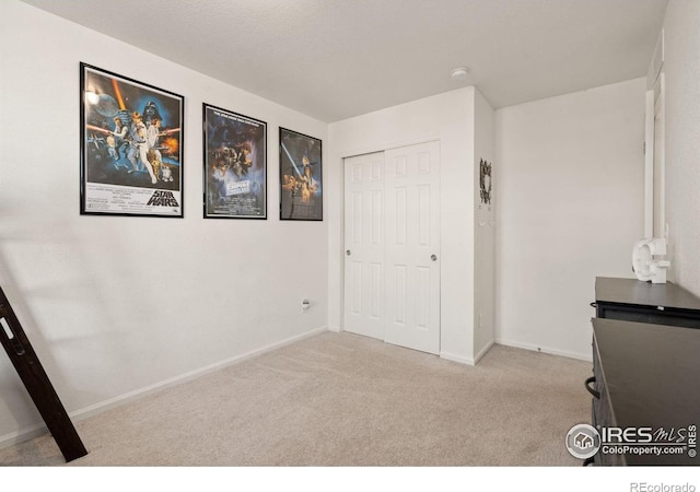 unfurnished bedroom with carpet, baseboards, and a closet