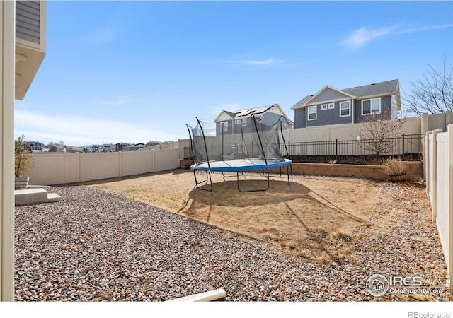 view of yard featuring a fenced backyard, a trampoline, and a patio