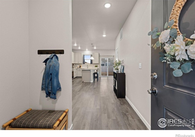 foyer with light wood-style floors, visible vents, baseboards, and recessed lighting