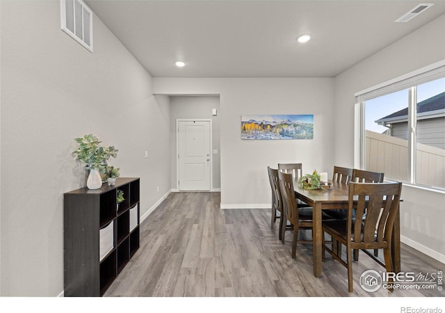 dining room featuring wood finished floors, visible vents, and baseboards