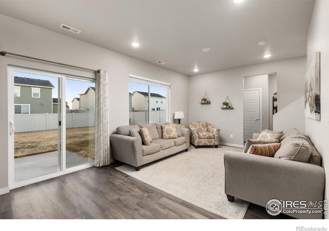 living area featuring baseboards, wood finished floors, visible vents, and recessed lighting