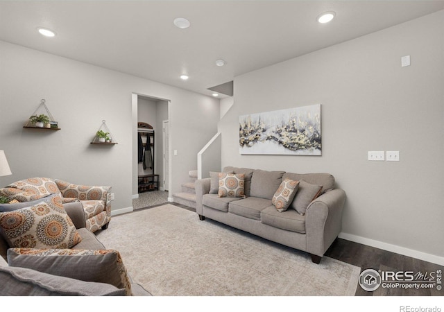 living room featuring baseboards, stairway, wood finished floors, and recessed lighting