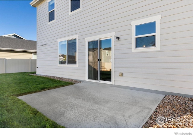 rear view of house featuring a patio area, fence, and a yard