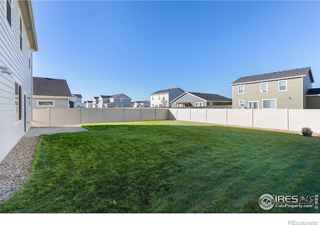 view of yard with a residential view and a fenced backyard