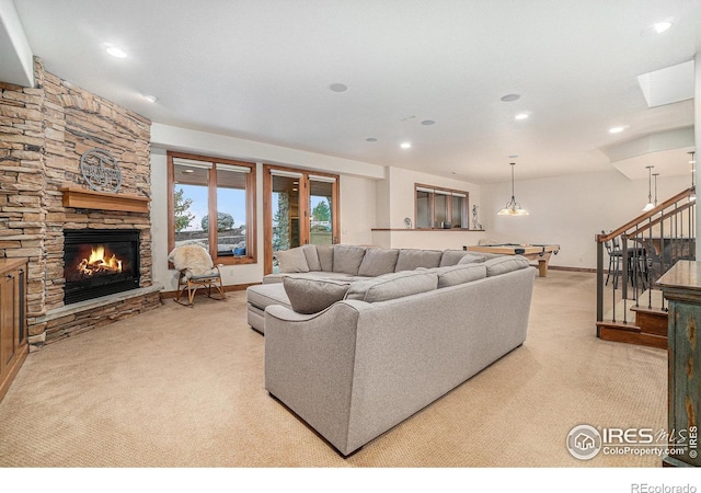 living area featuring recessed lighting, stairs, a fireplace, and light colored carpet