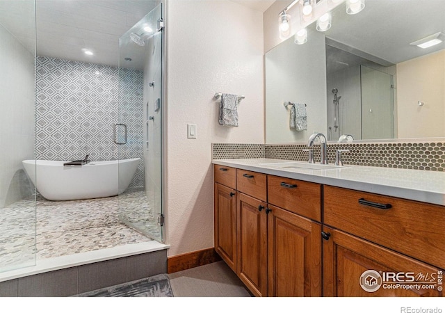 full bathroom with tile patterned floors, a soaking tub, vanity, baseboards, and walk in shower