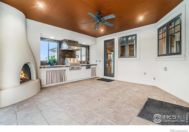 view of patio / terrace with a ceiling fan, a large fireplace, a grill, and area for grilling