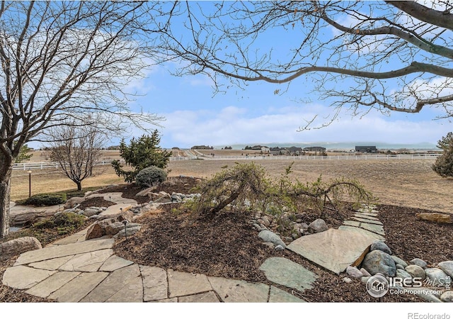 view of yard featuring fence and a rural view