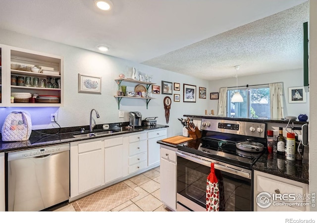 kitchen featuring appliances with stainless steel finishes, a textured ceiling, white cabinetry, open shelves, and a sink