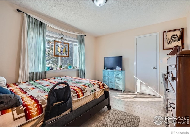 bedroom with wood-type flooring and a textured ceiling