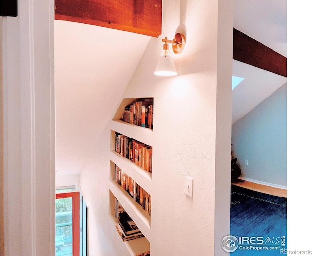 interior space with lofted ceiling with beams, built in features, and baseboards