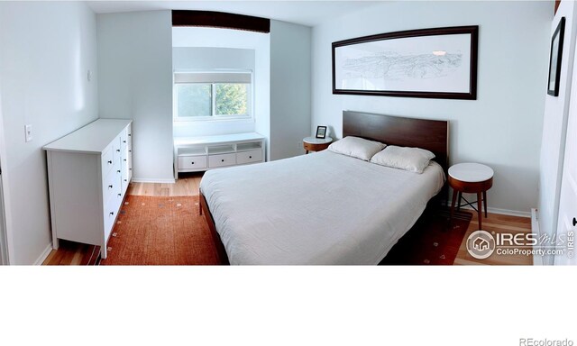 bedroom featuring wood finished floors and baseboards