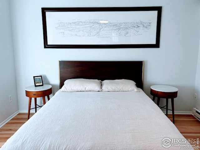 bedroom with baseboards and wood finished floors