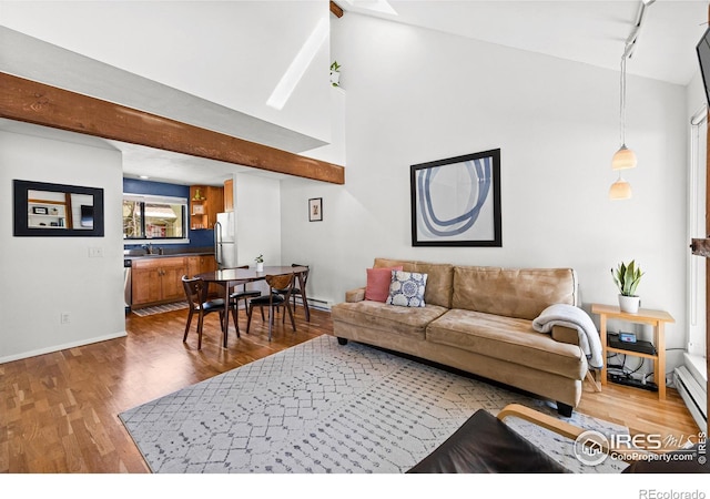 living area featuring wood finished floors, baseboards, high vaulted ceiling, beam ceiling, and track lighting