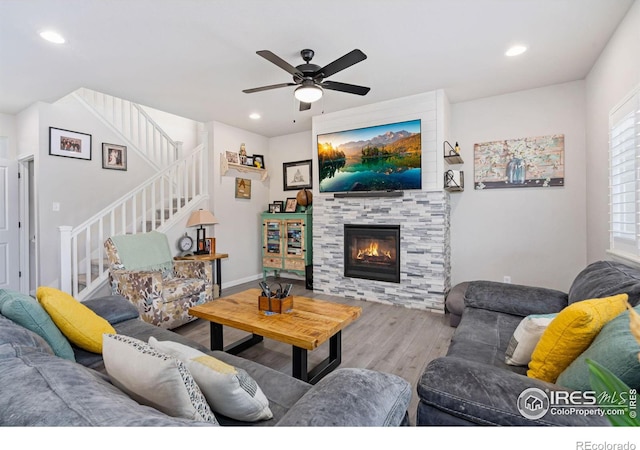 living room featuring recessed lighting, stairway, wood finished floors, and a tile fireplace