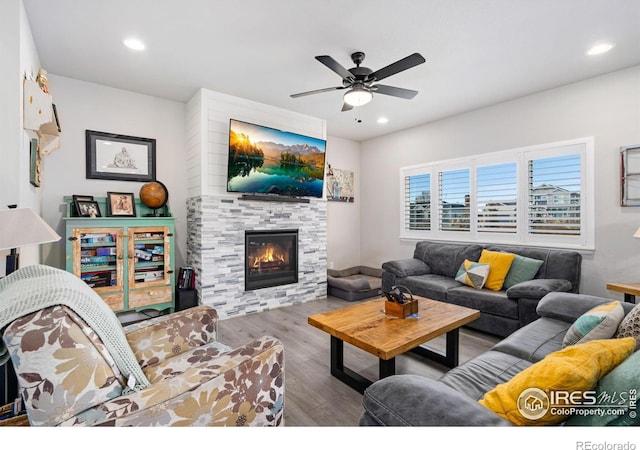 living area with a tile fireplace, wood finished floors, and recessed lighting