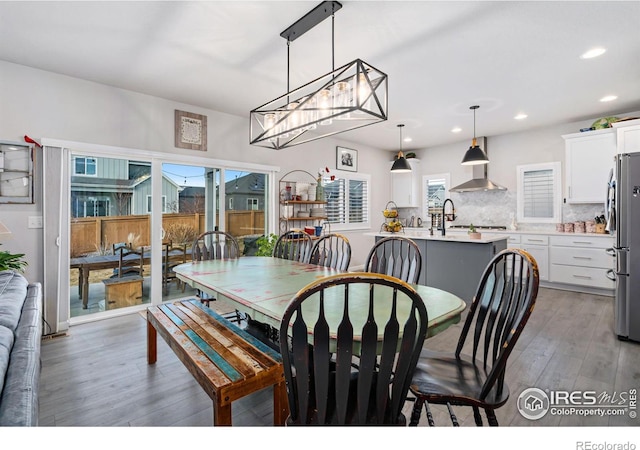 dining space with light wood finished floors, a wealth of natural light, and recessed lighting