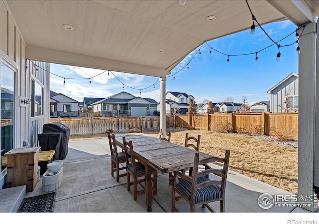 view of patio / terrace with outdoor dining space, a fenced backyard, a residential view, and area for grilling