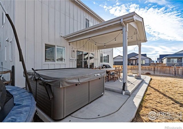 view of patio featuring a hot tub and fence