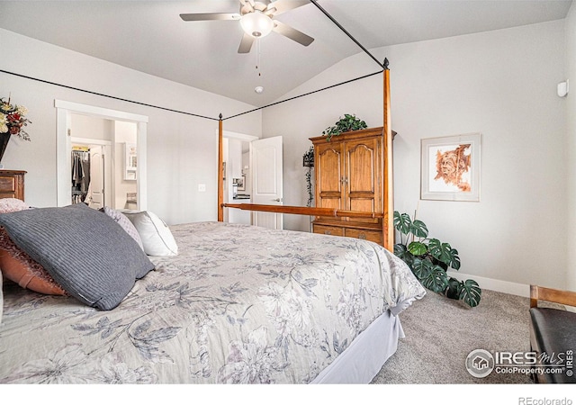 carpeted bedroom featuring a walk in closet, baseboards, vaulted ceiling, and a ceiling fan