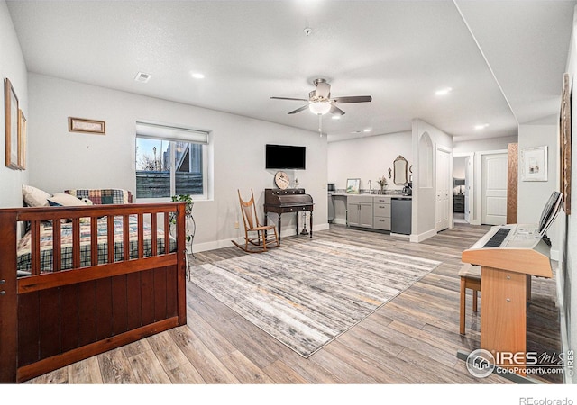 bedroom featuring light wood-style flooring, recessed lighting, a sink, visible vents, and baseboards