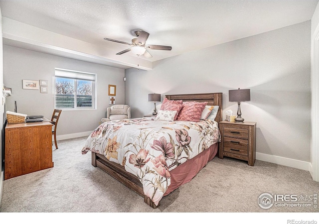 bedroom featuring a textured ceiling, baseboards, a ceiling fan, and light colored carpet